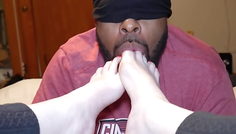 A brunette in a red dress and stockings is getting her feet filled